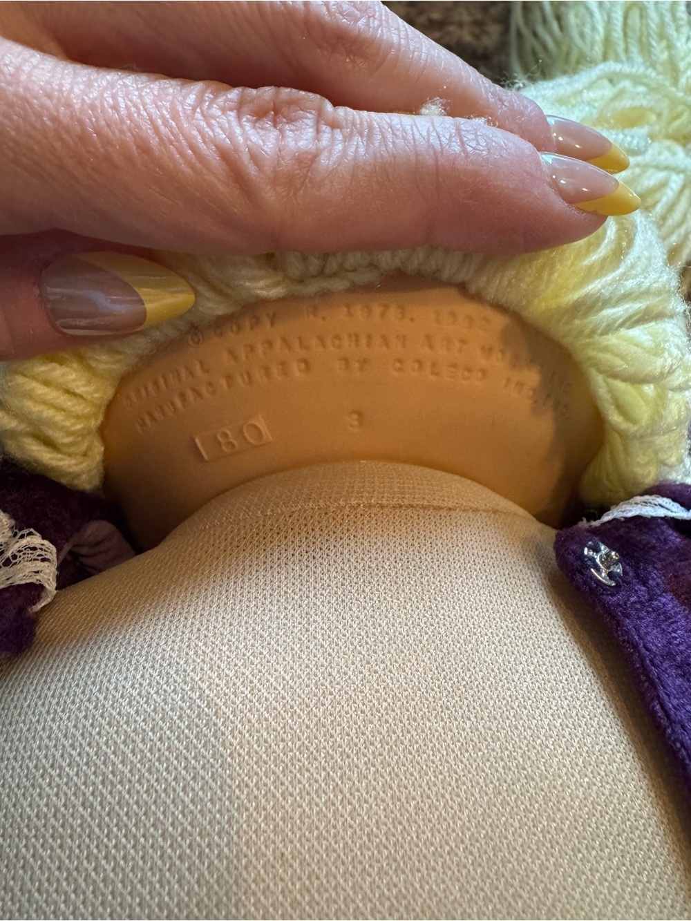 A Cabbage Patch Kid doll with blonde yarn hair and a purple dress - Picture 9 of 11